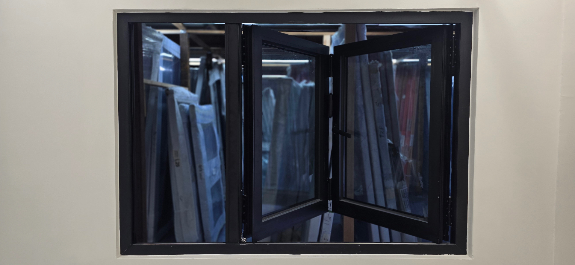 Black aluminum bi-fold window unit installed in a wall opening