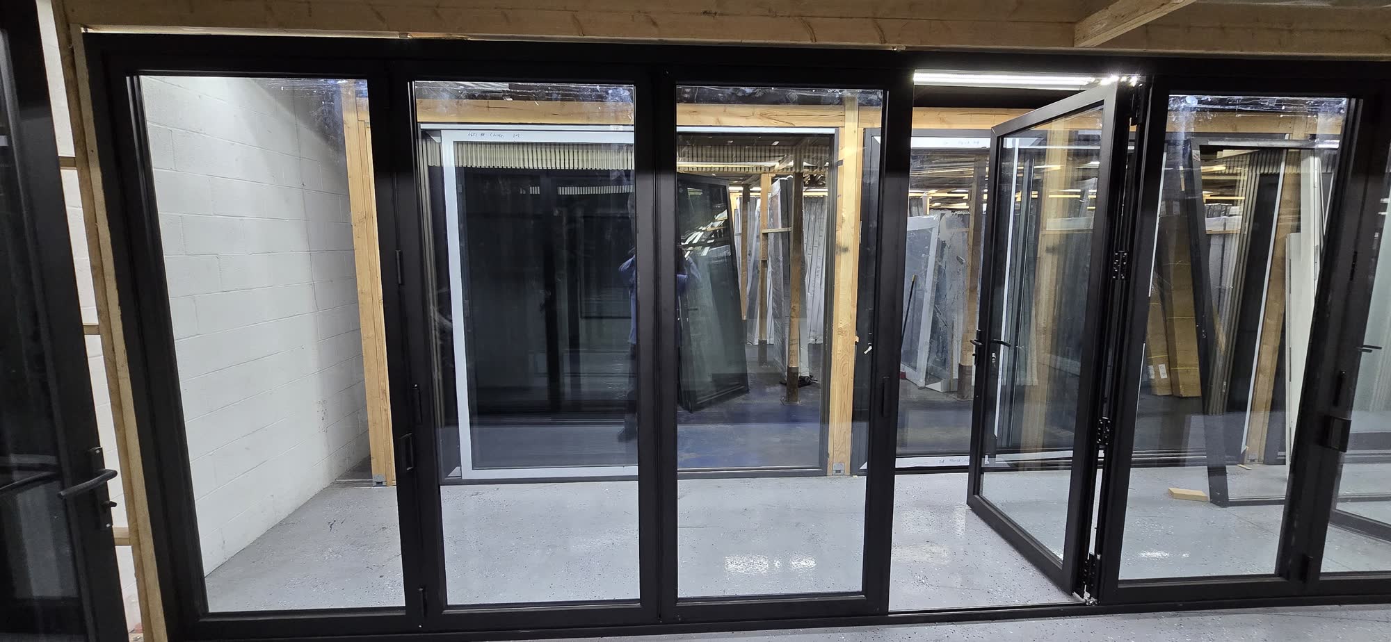 Multi-panel aluminum bi-fold door partially open